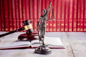 A court symbol with a hammer and civil litigation books in the background.