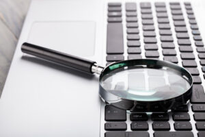A computer keypad with a magnifying glass indicating a investigation into an internal theft case.